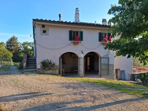 a large white house with a gate and a yard at Felciolina - Medieval Country House in Troghi