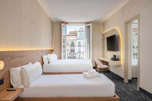 a hotel room with two beds and a window at FORTINN Puerta del Sol in Madrid