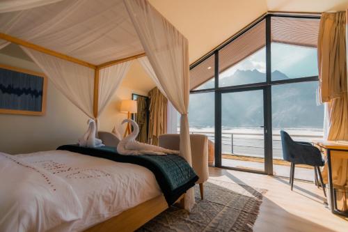 a bedroom with a bed with two birds sitting on it at Khoj Resorts Shigar in Shigar