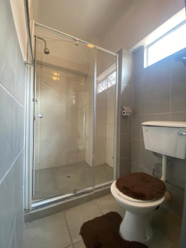 a bathroom with a glass shower and a toilet at Fiet Star in Midrand