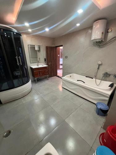a large bathroom with a tub and a sink at Hotel V Square in Lucknow