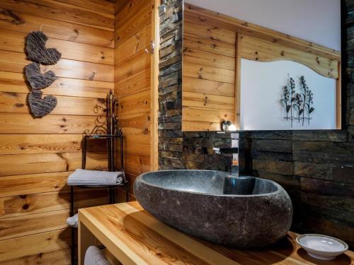 a bathroom with a stone sink on a wooden wall at Petererhof in Ellmau