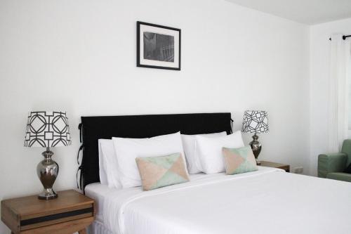 a bedroom with a white bed and a green chair at Aster 9 House in Bangkok