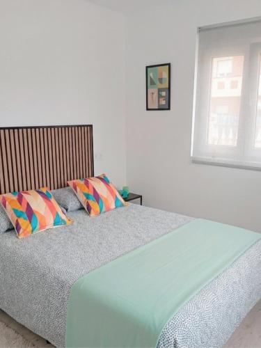 a bedroom with a bed with two pillows on it at La Casita de Suances 1- Jardín y Parking, Ideal Familias y Mascotas in Suances