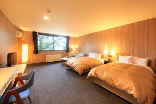 una camera d'albergo con due letti e una finestra di Yutorelo Karuizawa Hotel a Karuizawa