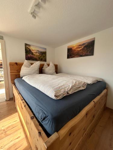 a bed with a wooden frame in a bedroom at Ferienhaus Abendsonne in Sebnitz - Sächsische Schweiz in Sebnitz