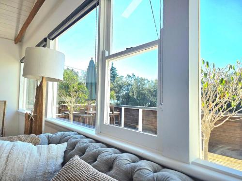 a living room with a couch and a large window at Beach House in Surf Beach