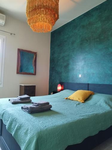 a bedroom with a large bed with a green wall at Alexandria Aegean View in Gavrio
