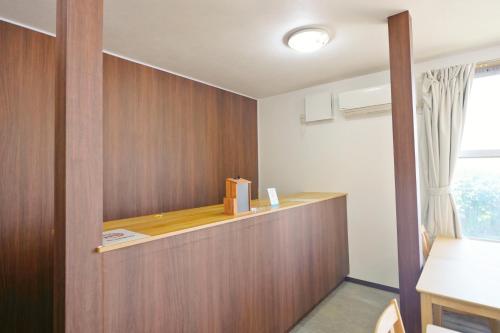 a room with a wooden wall with a box on a counter at 海凪旅館 in Tateyama