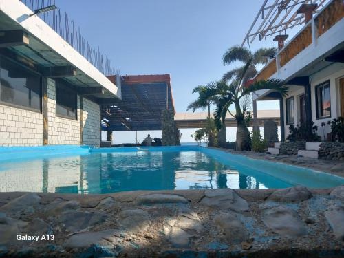 a swimming pool in front of a building at White Castle Beach Resort in Iba
