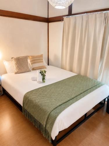 a bedroom with a bed with a flower arrangement on it at Yoshimi Stay Kawaguchi in Kawaguchi