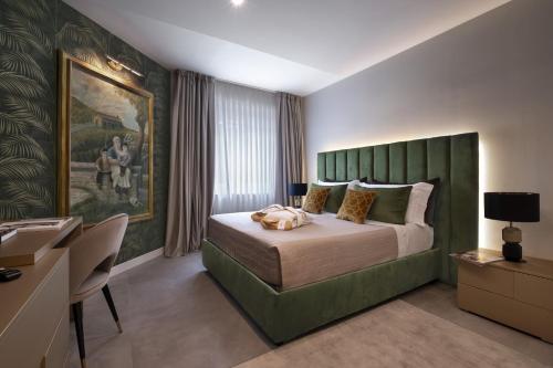 a bedroom with a large bed with a green headboard at Giorgio Raggi Hospitality in Terni