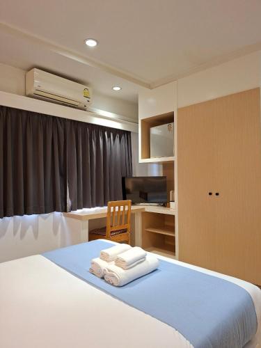 a bedroom with a bed and a desk with a computer at Yukata Space in Sathani Nakhon Si Thammarat