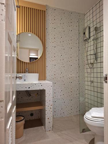 a bathroom with a sink and a mirror and a toilet at Yukata Space in Sathani Nakhon Si Thammarat