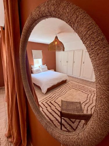 a bedroom with a large wicker hanging chair and a bed at Villa TerraVerde in Al Ghar