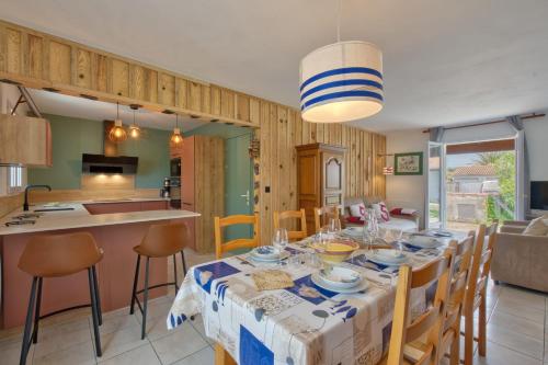 a dining room and kitchen with a table and chairs at Maison Oléron - Welkeys in Dolus-d'Oléron