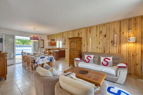 a living room with a couch and a table at Maison Oléron - Welkeys in Dolus-d'Oléron