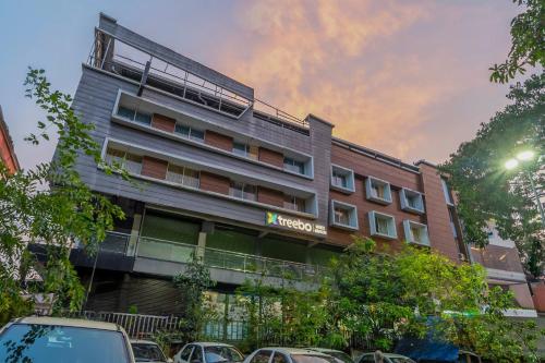 a hotel with cars parked in front of it at Treebo Medco Mansion in Kozhikode