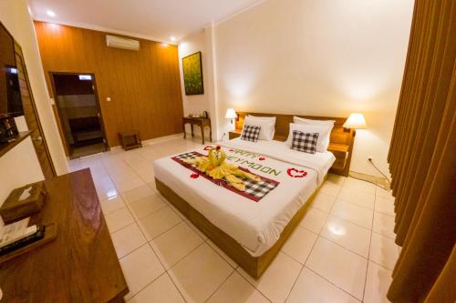 a bedroom with a large bed with flowers on it at Capung Cottages in Ubud