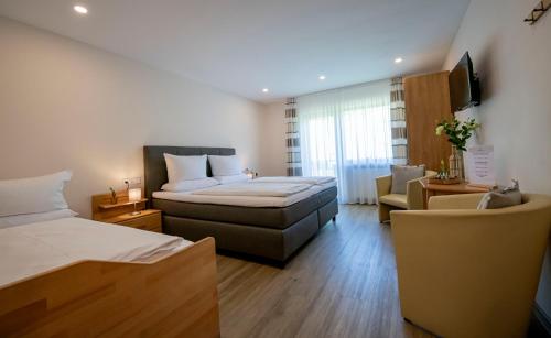 a hotel room with two beds and a couch at Weingut Erich Serwazi in Mesenich
