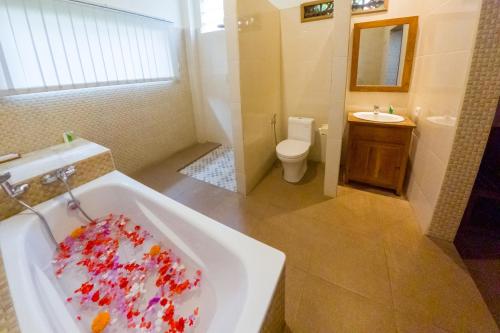 a bathroom with a sink and a tub with a toilet at Capung Cottages in Ubud