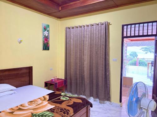 a bedroom with a bed and a sliding glass door at Toba Boi in Tuktuk Siadong