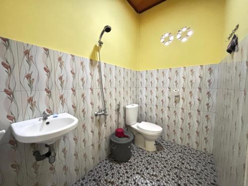 a bathroom with a sink and a toilet at Toba Boi in Tuktuk Siadong