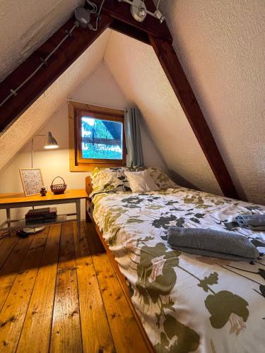 a bedroom with a bed and a desk in a attic at Jó, hogy itt vagy! in Orfű