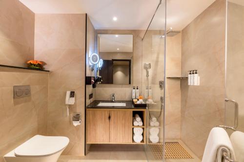 a bathroom with a shower and a toilet and a sink at Plume Hotels, India Expo Mart, Greater Noida in Greater Noida