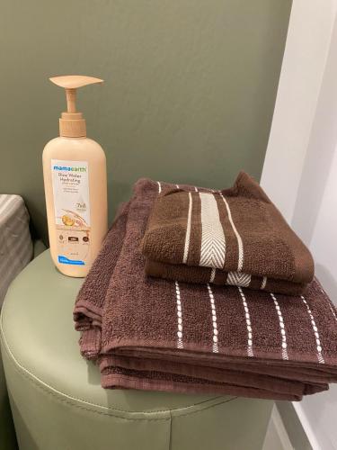 a pile of towels and a bottle of soap on a stool at KD Homes - Elite studio stay in Surat