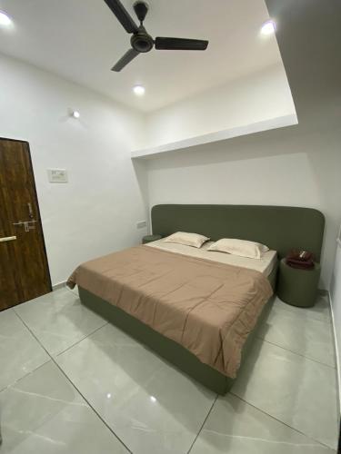 a bedroom with a bed with a ceiling fan at KD Homes - Elite studio stay in Surat