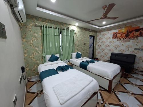 a room with three beds and a ceiling fan at Hotel Dev Inn in Dhangadhi