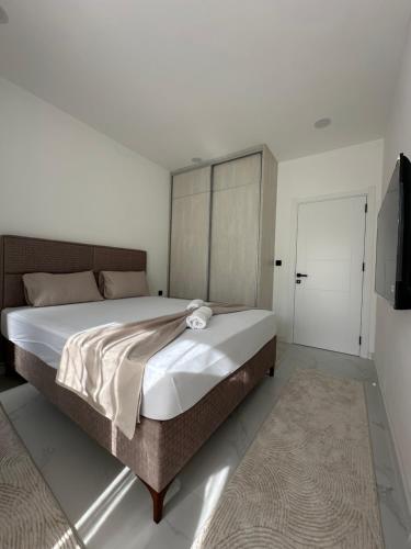 a bedroom with a large bed and a television at Miri Apartments in Ulcinj