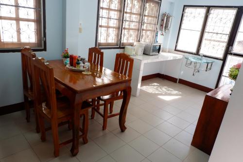 a dining room with a wooden table and chairs at Ban Yenjid in Phra Nakhon Si Ayutthaya