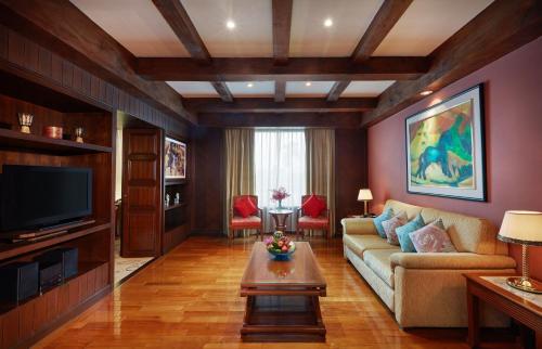 a living room with a couch and a tv at The Davis Bangkok in Bangkok