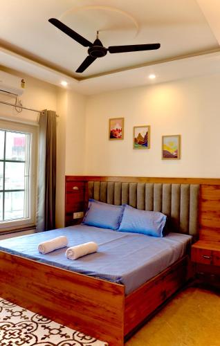 a bedroom with a large wooden bed with blue pillows at Aarunya Stays in Rishīkesh