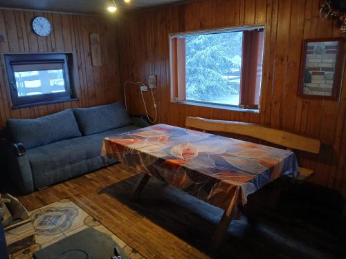 a living room with a table and a couch at Bajorinų sodyba in Varėna