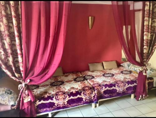 a bedroom with a bed with pink curtains at Jetset Parisian Holiday Home in Cesson