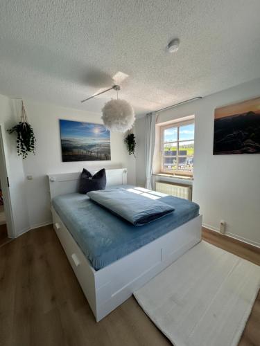 a bedroom with a bed with blue sheets and a window at Ferienwohnung Am Weifberg in Hinterhermsdorf Sächsische Schweiz in Hinterhermsdorf