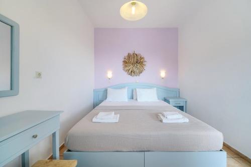 a white bedroom with a bed with two towels at Archodissa Pansion in Alyki