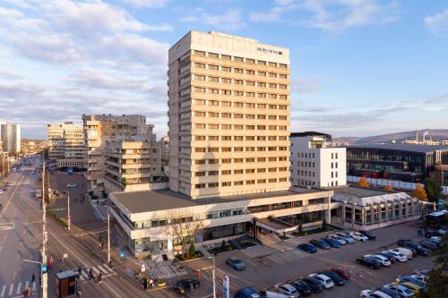 a tall building in a city with a parking lot at Hotel Moldova in Iaşi