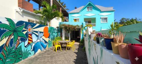 a wall with a table and chairs in front of a house at Ô PasSage - Kaz Auberge in Saint-Pierre