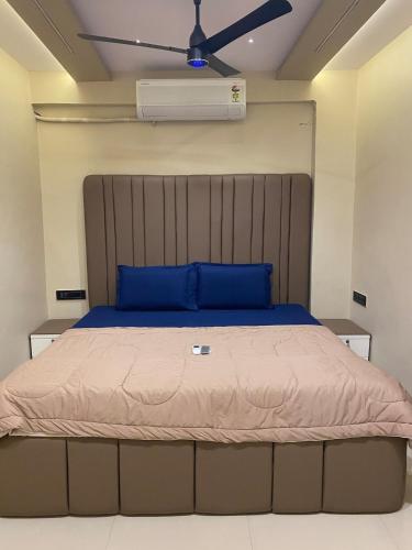 a bedroom with a bed with a blue pillow and a ceiling fan at KD Homes in Surat