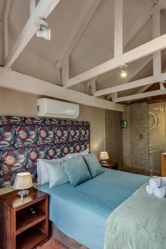 a bedroom with a large blue bed with a wall at Mill Park Corner Cottages in Port Elizabeth