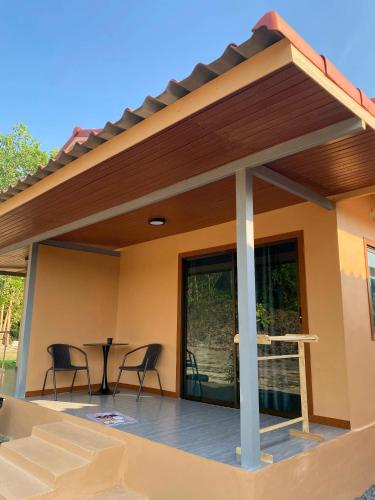 a patio with chairs and a table on a deck at The sun homestay01 in Ko Kood