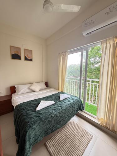 a bedroom with a bed and a large window at Little Retreats in Nedumbassery