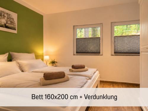 two beds in a room with two windows at Waldidyll - Ruhe mitten im Wald in Dahlen