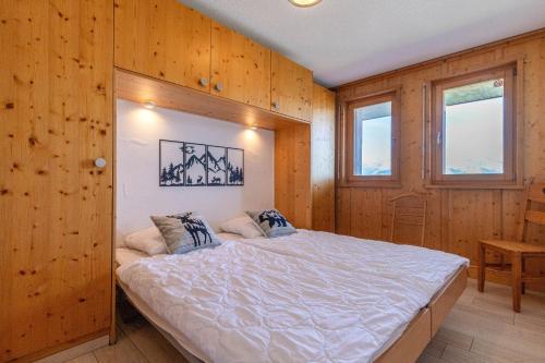 a bedroom with a bed in a wooden wall at Plein Ciel VA 022 - MOUNTAIN apartment 4 pers in Veysonnaz