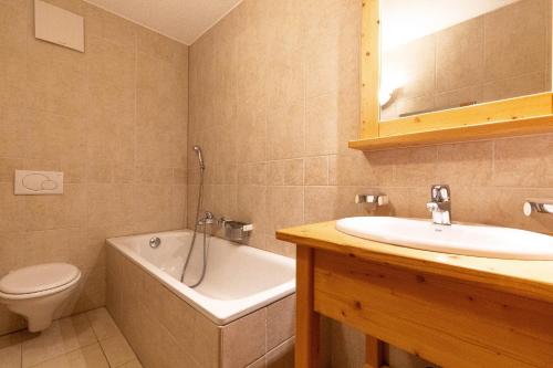 a bathroom with a tub and a sink and a toilet at Plein Ciel VA 022 - MOUNTAIN apartment 4 pers in Veysonnaz