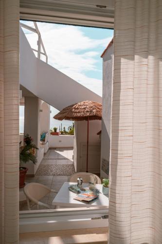 a balcony with a table and an umbrella at Appartamenti Baia di Citara in Forio d'Ischia